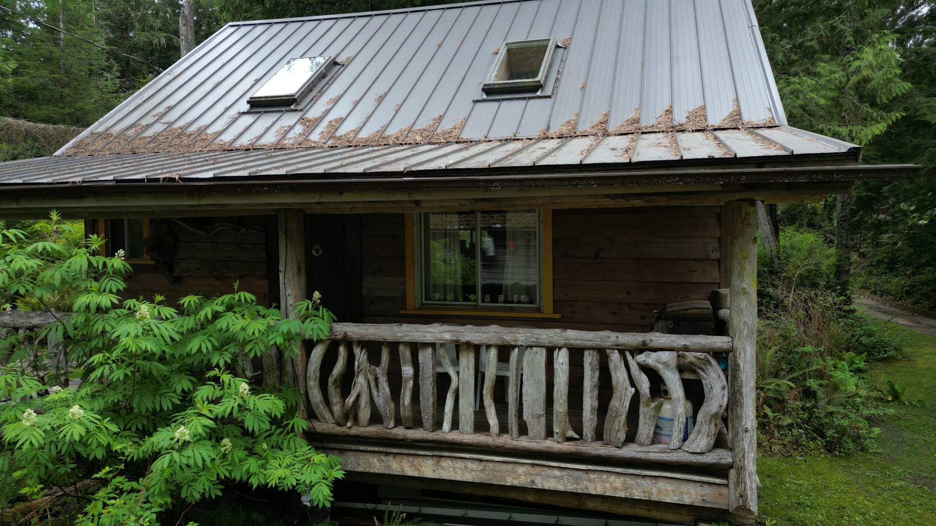 Cedar cabin with handcrafted driftwood railing and metal roof