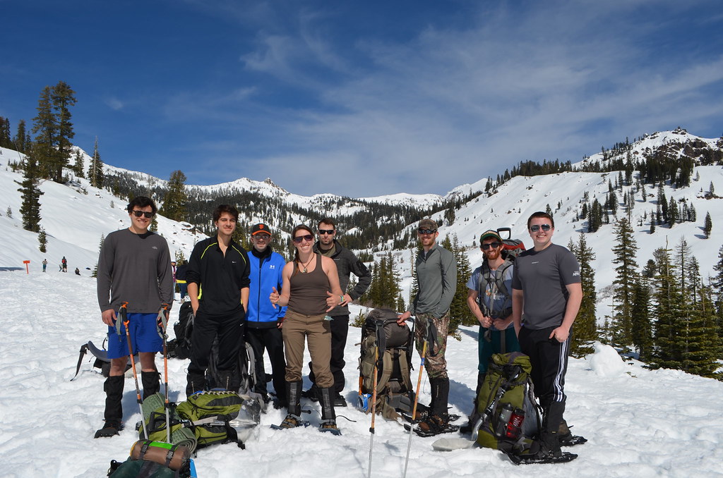 A group of adults snowshoeing together through fresh snow
