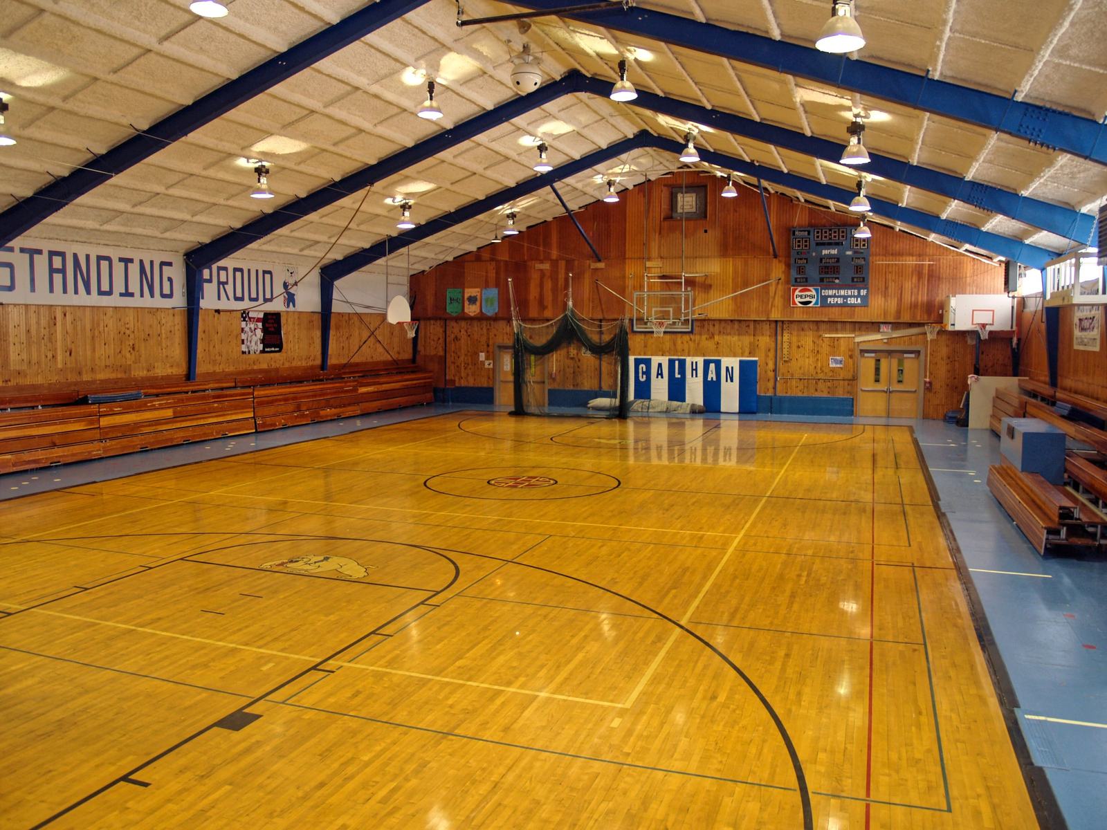 A school gymnasium set up for one hundred campers to sleep on gym mats
